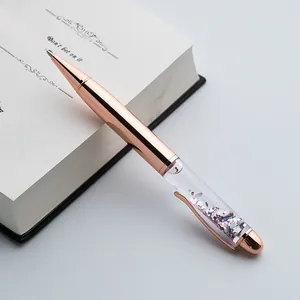 Close-up view of a luxury rose gold metal ballpoint pen featuring sparkling silver sequins.
