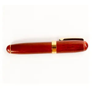 Detailed view of a vintage rosewood rollerball pen with elegant gold clip and accents