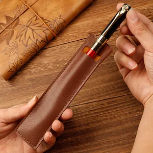 Retro brown PU leather single fountain pen sleeve pouch being held on a wooden surface