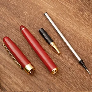 Vintage redwood rollerball pen disassembled showing barrel cap and refill with gold trim