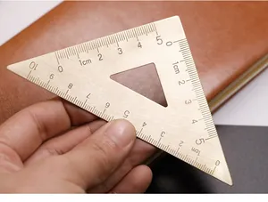 Detalle de una escuadra vintage de latón con escala métrica de 10 cm grabada con láser