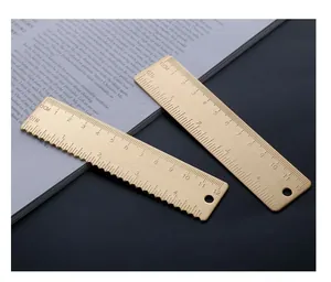 Close-up showing the brushed texture and engraved scales of two vintage brass rulers