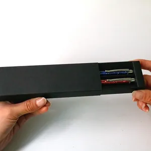 Élégant coffret cadeau noir à tiroir avec deux stylos à paillettes sur fond blanc