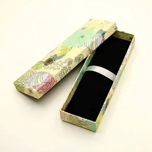 Elegantes Stift-Geschenkkarton mit Blumendruck, schwarzem Samtfutter und Satinband.