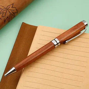 Elegant retro wooden ballpoint pen with silver metal accents on a kraft notebook