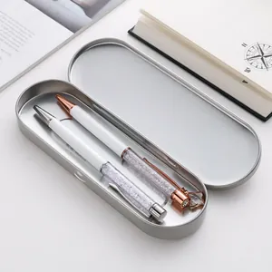 Zilveren ovale metalen doos met twee elegante witte en roségouden kristallen balpennen