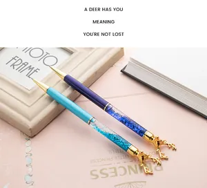 Close-up of quicksand ballpoint pens with golden deer head toppers in blue and purple.