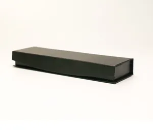 Primer plano de una elegante caja de regalo negra con cierre magnético para plumas.