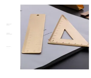 Close-up detail of retro brass straight and triangle ruler set on white magazine