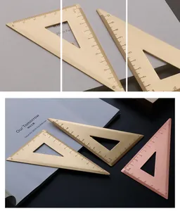 Close-up of vintage brass triangle ruler with precise laser-etched metric scales.