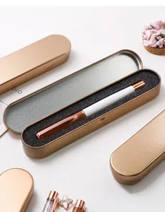 Detail of a rose gold tin box with a white and copper pen on black sponge padding