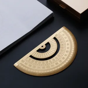 Vintage brass semicircular 180-degree protractor on dark desktop surface