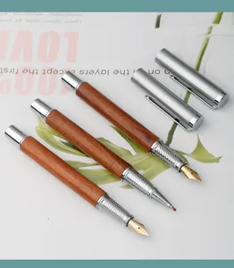 Macro detail of luxury rosewood fountain and rollerball pens with silver trim