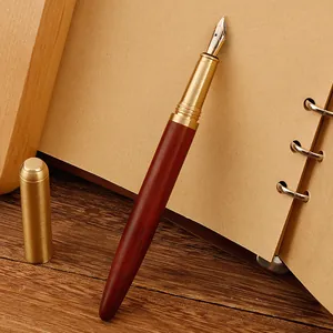 Elegant vintage brass and sandalwood fountain pen resting on a kraft paper notebook
