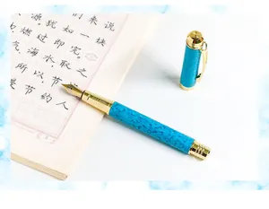 Detail view of a turquoise marble fountain pen with elegant gold trim and nib.