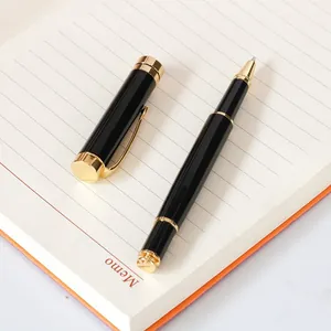 Elegant black and gold metal rollerball pen resting on a white lined memo notebook page
