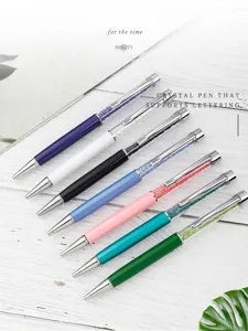 Penne a sfera in metallo in vari colori con eleganti decorazioni in cristallo su legno.