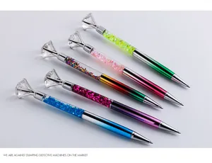 Detailed view of colorful glitter ballpoint pens with large crystal diamond toppers.