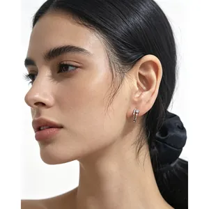 Gros plan détaillé d'une boucle d'oreille en argent avec zircons portée par un mannequin