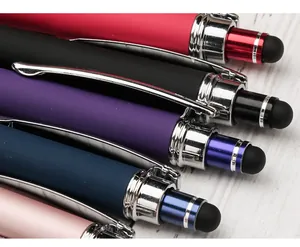 Close-up of colorful rubberized stylus ballpoint pens with chrome clips on wood background.