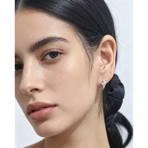 Gros plan de boucles d'oreilles feuille en argent s925 avec zircons sur un modèle