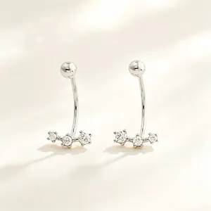 Primer plano de elegantes pendientes de plata s925 en forma de C con circonitas brillantes