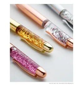 Close-up detail of stylish metal ballpoint pens with colorful quicksand and glitter.