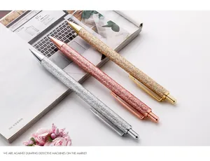 Macro view of three elegant glitter retractable metal ballpoint pens in gold and silver finishes