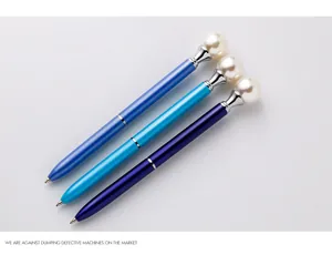 Detail view of three elegant pearl top metal ballpoint pens in various blue shades for gifts.