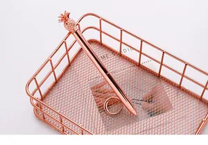 Elegant rose gold ballpoint pen with a decorative pineapple top detail in a mesh basket.