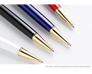 Close-up of four luxury metal ballpoint pens with polished gold-plated tips