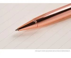 Macro detail showing the polished rose gold metallic tip of a stylish ballpoint pen