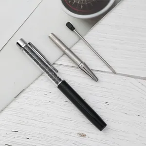 Elegant crystal ballpoint pen with black rhinestones and extra refill on white wood.