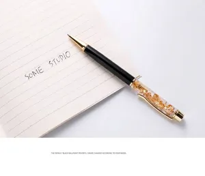 Detailed macro view of an elegant gold foil ballpoint pen featuring a nib and black barrel
