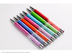Macro shot of elegant metal ballpoint pens with colorful crystal rhinestone barrel details