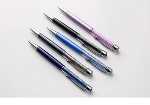 Close-up of elegant metal ballpoint pens with sparkling crystal rhinestone filling