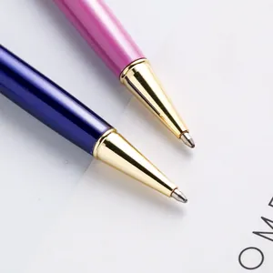 Close-up of elegant blue and pink metal twist ballpoint pens with gold tips
