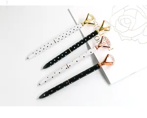 Close-up of creative ballpoint pens with large diamond tops and polka dot patterns.
