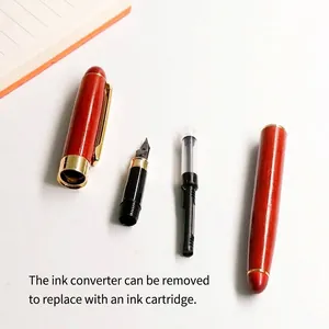 Disassembled elegant redwood fountain pen with gold metal trim and removable ink converter