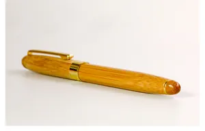 Macro detail of natural bamboo fountain pen with elegant gold metallic accents