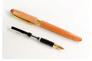 Detail view of a wooden bamboo fountain pen with a gold iridium nib and ink converter.
