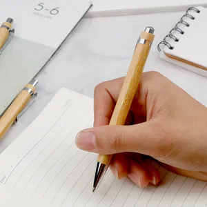 Bolígrafo de bambú natural con mecanismo de clic retráctil sostenido en la mano