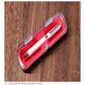Primer plano de un bolígrafo blanco en una caja de regalo magnética roja y transparente.