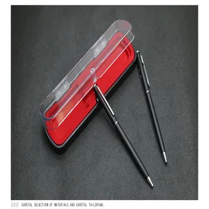 Primer plano de dos bolígrafos negros en una caja de regalo magnética roja transparente.