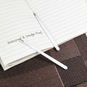 White plastic ballpoint pen refills on a notebook with waterproof ink performance.