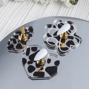 Cow print magnetic nail art practice stand with gold metal holders on acrylic base