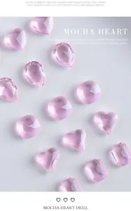 Close-up van roze hartvormige en gefacetteerde kristallen nagelkunstbedeltjes