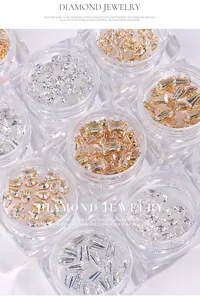 Macro detail of various zircon nail art rhinestones including teardrop and marquise shapes in jars