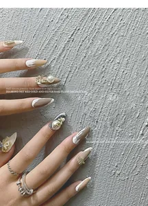 Detail showing luxury pearl bow and star chain charms on manicured nail art decoration