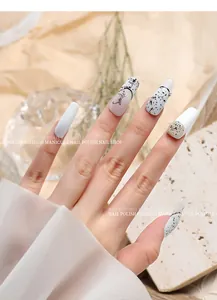Detail view of quail egg shell nail art with black and white spots and Smile text